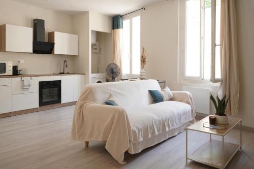 un salon blanc avec un canapé et une table dans l'établissement Studio lumineux intra-muros, à Avignon