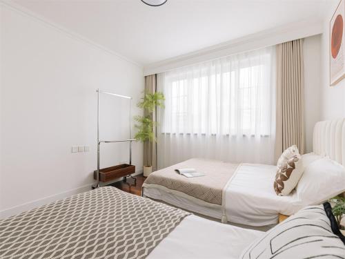 a hotel room with two beds and a window at Book and Bed-People's Square in Shanghai