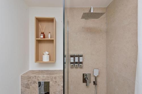 une douche dans une salle de bain avec une porte vitrée dans l'établissement Cosy appartement rénové - Tropézienne - DV, à Mougins