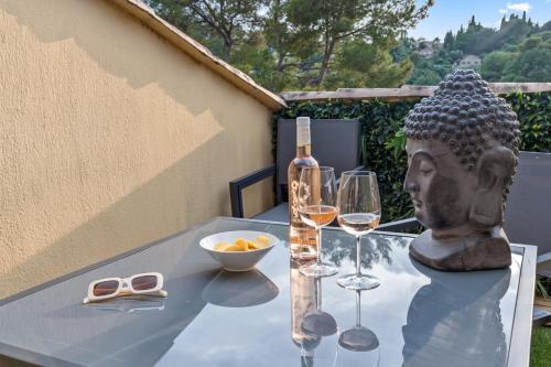 une table avec une statue et des verres de vin dans l'établissement Cosy appartement rénové - Tropézienne - DV, à Mougins