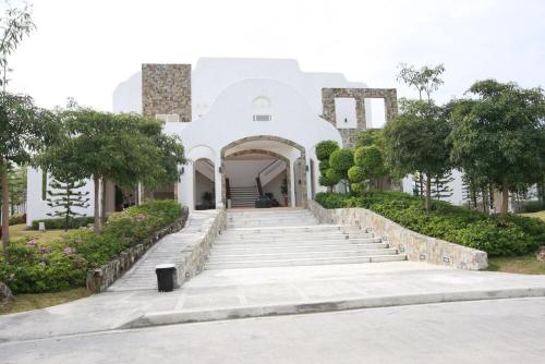 Un edificio blanco con escaleras al frente. en Ace's Villa, Calapan, en Calapan