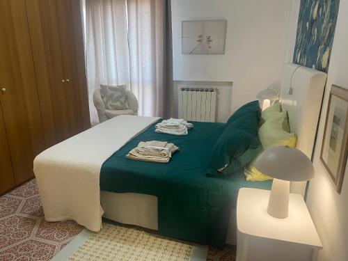 a bedroom with a bed with a green blanket at Al B6 CLOSE TO VENICE in Mogliano Veneto