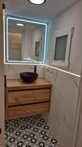 a bathroom with a sink and a mirror at Apartamentos Pino in Benidorm