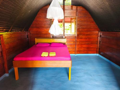 a bed in a room with a purple mattress at Ira Bungalows Pulau Banyak in Alaban