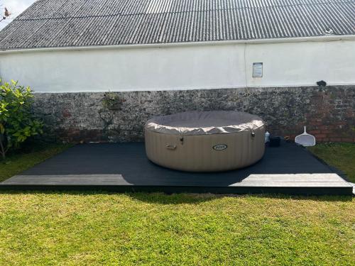 a large tub sitting next to a brick wall at Family & friends get together birthday hot tub in Porthcawl
