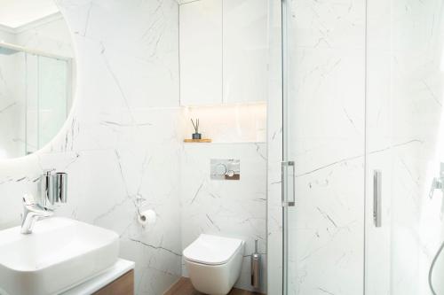 ein weißes Badezimmer mit Toilette und Dusche in der Unterkunft Willa Matejki - Apartament 8b in Przemyśl