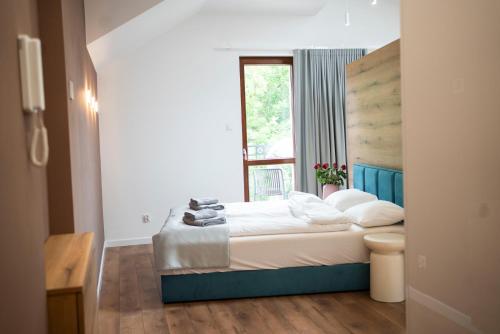 ein Schlafzimmer mit einem Bett und einem Fenster in der Unterkunft Willa Matejki - Apartament 8b in Przemyśl