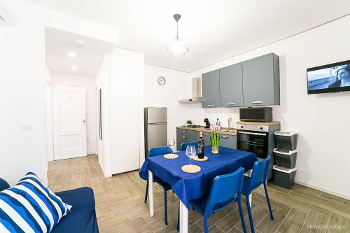 a kitchen with a blue table and chairs in a room at Casa Sollai in Monserrato