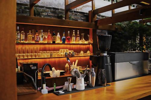 a counter with a bar with alcohol bottles on a shelf at Gulangyu Liuyue Garden Resort Hotel in Xiamen