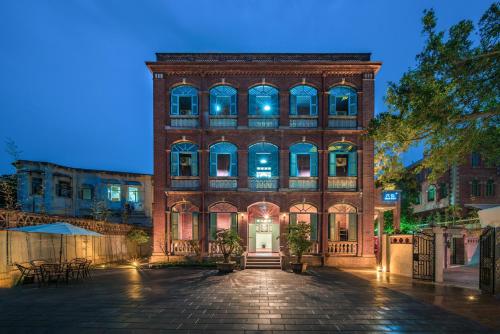 an old brick building with a front door at night at Gulangyu Liuyue Garden Resort Hotel in Xiamen
