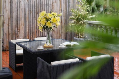 a table with a vase of yellow flowers on it at Gulangyu Liuyue Garden Resort Hotel in Xiamen