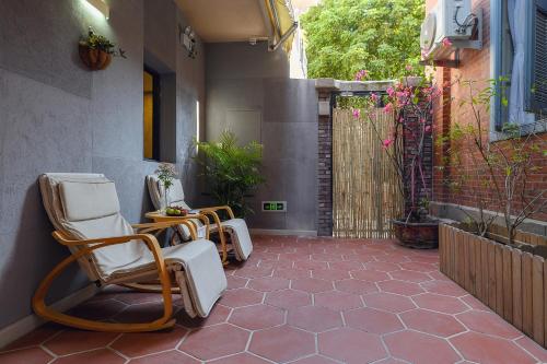 a patio with rocking chairs and a fence at Gulangyu Liuyue Garden Resort Hotel in Xiamen