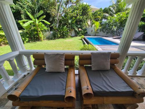 a porch with two chairs and a swimming pool at Kaz Memel in Beau Vallon