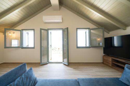 a living room with a couch and a tv at THISEFS luxury apartments Kefalonia in Antipata