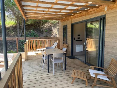 une terrasse en bois avec une table et des chaises dessus dans l'établissement La vallée, à Belvédère