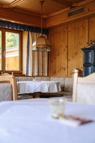 a dining room with a table and a large window at Pension Schlossberg in Mittersill