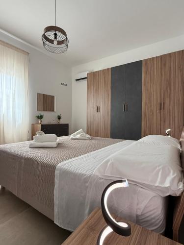 a bedroom with a large white bed with a chair at Casa Vacanze - Uliveto in Sciacca