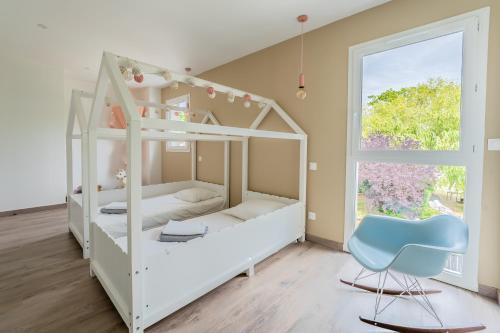 ein Schlafzimmer mit zwei Etagenbetten und einem blauen Stuhl in der Unterkunft Villa climatisée avec piscine et stationnements in Vendargues