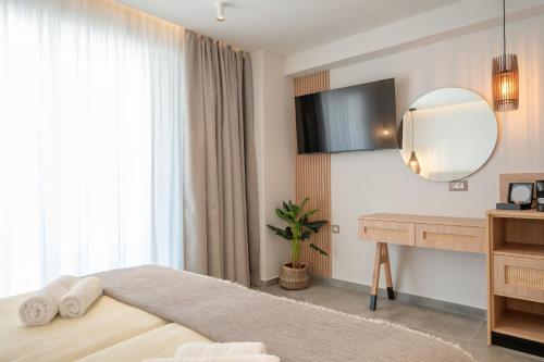 a bedroom with a bed and a desk and a mirror at Panorama Seaside in Mastichari