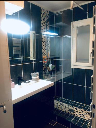 une salle de bain noire avec un lavabo et un miroir dans l'établissement Deauville Sevigné 6p 2ch G Terrace pool tennis, à Deauville