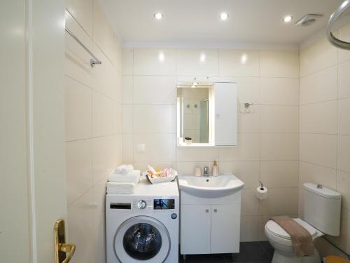 a bathroom with a washing machine and a sink at Patrikon House in Kardamaina