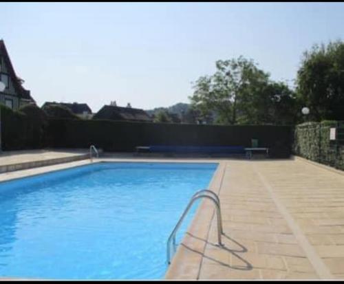 une grande piscine bleue dans une cour dans l'établissement Deauville Sevigné 6p 2ch G Terrace pool tennis, à Deauville