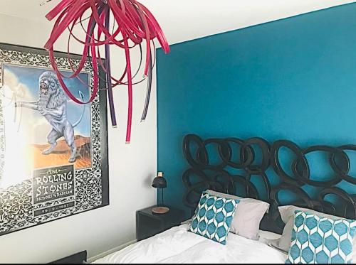 une chambre avec un mur bleu avec un lit et un poster dans l'établissement Deauville Sevigné 6p 2ch G Terrace pool tennis, à Deauville