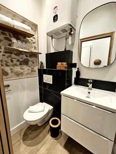 une salle de bain avec des toilettes blanches et un miroir dans l'établissement Azura, à Antibes