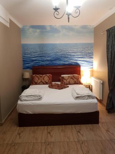 a bedroom with a bed with a painting of the ocean at Villa Tropico śniadanie i obiadokolacja in Pobierowo