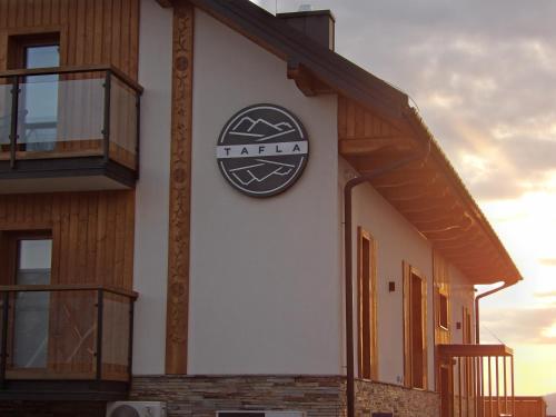 a building with a clock on the side of it at Apartamenty TAFLA nad Jeziorem Czorsztyńskim in Kluszkowce