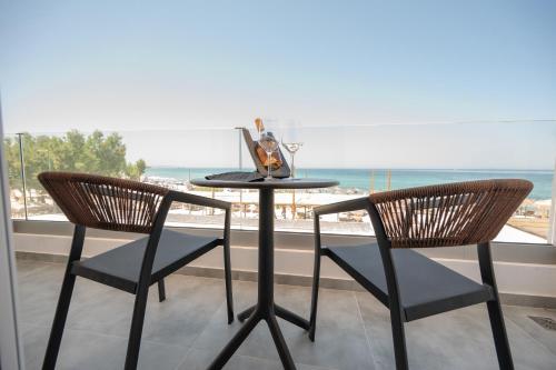 a table with two chairs and a laptop on it at Panorama Seaside in Mastichari