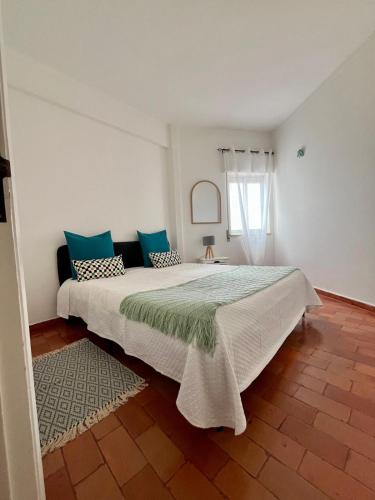 a bedroom with a large bed with blue pillows at Sea Light Seaview Vista Mar Apartment - Luz, Lagos in Luz