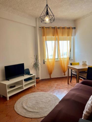 a living room with a flat screen tv and a table at Sea Light Seaview Vista Mar Apartment - Luz, Lagos in Luz