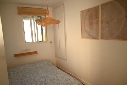 a bedroom with a bed and a window and a lamp at Casa en casco antiguo de Barbate in Barbate