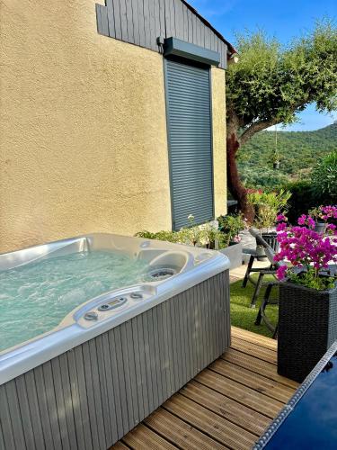 a hot tub on a deck next to a building at Petit Havre de Paix avec Jacuzzi Luxe & Jardin Privatif Zen in Cavalaire-sur-Mer