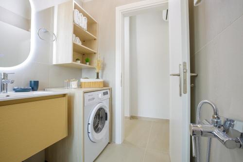 a white laundry room with a washer and dryer at Cosy apartments in Análipsis