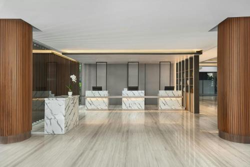a lobby with wood columns and a lobby with white chairs at Fairfield by Marriott Bali Kuta Ngurah Rai in Kuta