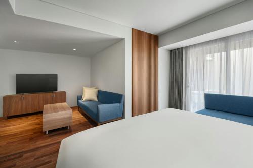 a hotel room with a bed and a tv at Fairfield by Marriott Bali Kuta Ngurah Rai in Kuta