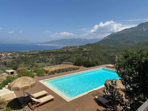 a swimming pool with chairs and a view of the ocean at Euphoria Suites in Avia