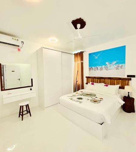 a white bedroom with a bed and a window at Crystal sea inn in Bileffahi