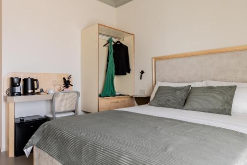 a bedroom with a bed and a green dress hanging on a closet at Domus Terravecchia in Agrigento