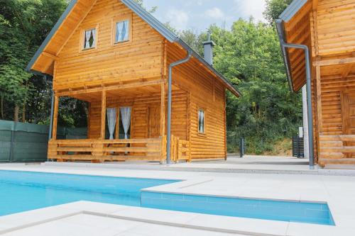 a wooden house with a pool in front of it at Hafizove ville na Uni in Illidža