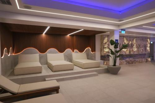 a lobby with white chairs and a couch and a plant at Grand Lubicz Uzdrowisko Ustka in Ustka