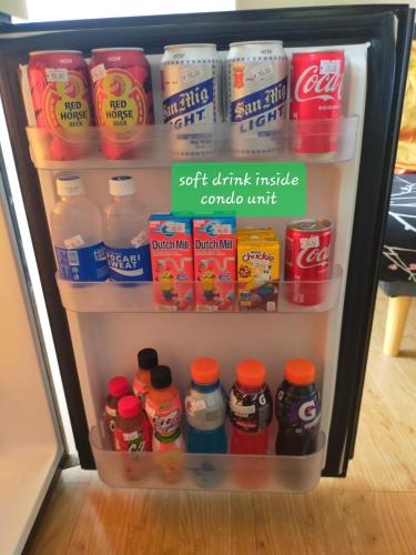 a refrigerator filled with lots of food and drinks at Two-Bedroom at San Remo Oasis in Cebu City