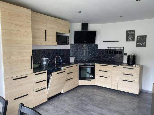 une grande cuisine avec des armoires et des appareils en bois dans l'établissement Confortable Appartement près de Metz pour 6 personnes, 