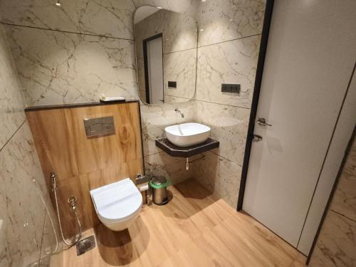 a bathroom with a toilet and a sink at Hotel Ocean Residency Thane West in Thane