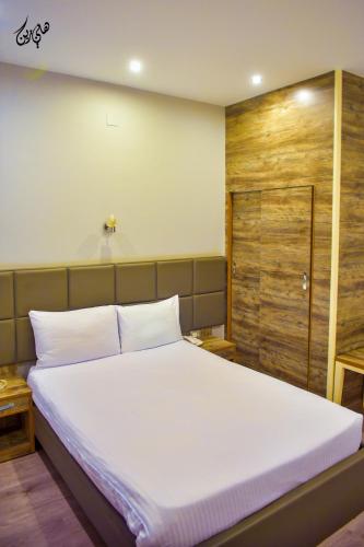 a bedroom with a white bed and a wooden door at Red Sea Hotel in Būr Tawfīq