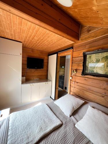 a bedroom with a bed in a room with wooden walls at Vuorijärvi cottage in Enonkoski