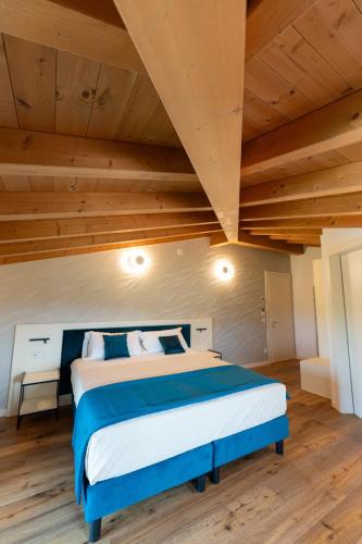 a bedroom with a large bed with a wooden ceiling at 4 Elementi Relais B&B Lonato del Garda in Lonato del Garda