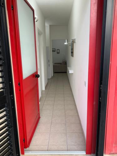 an empty hallway with a red door and a floor at Appartamento La Jolla Fano in Fano
